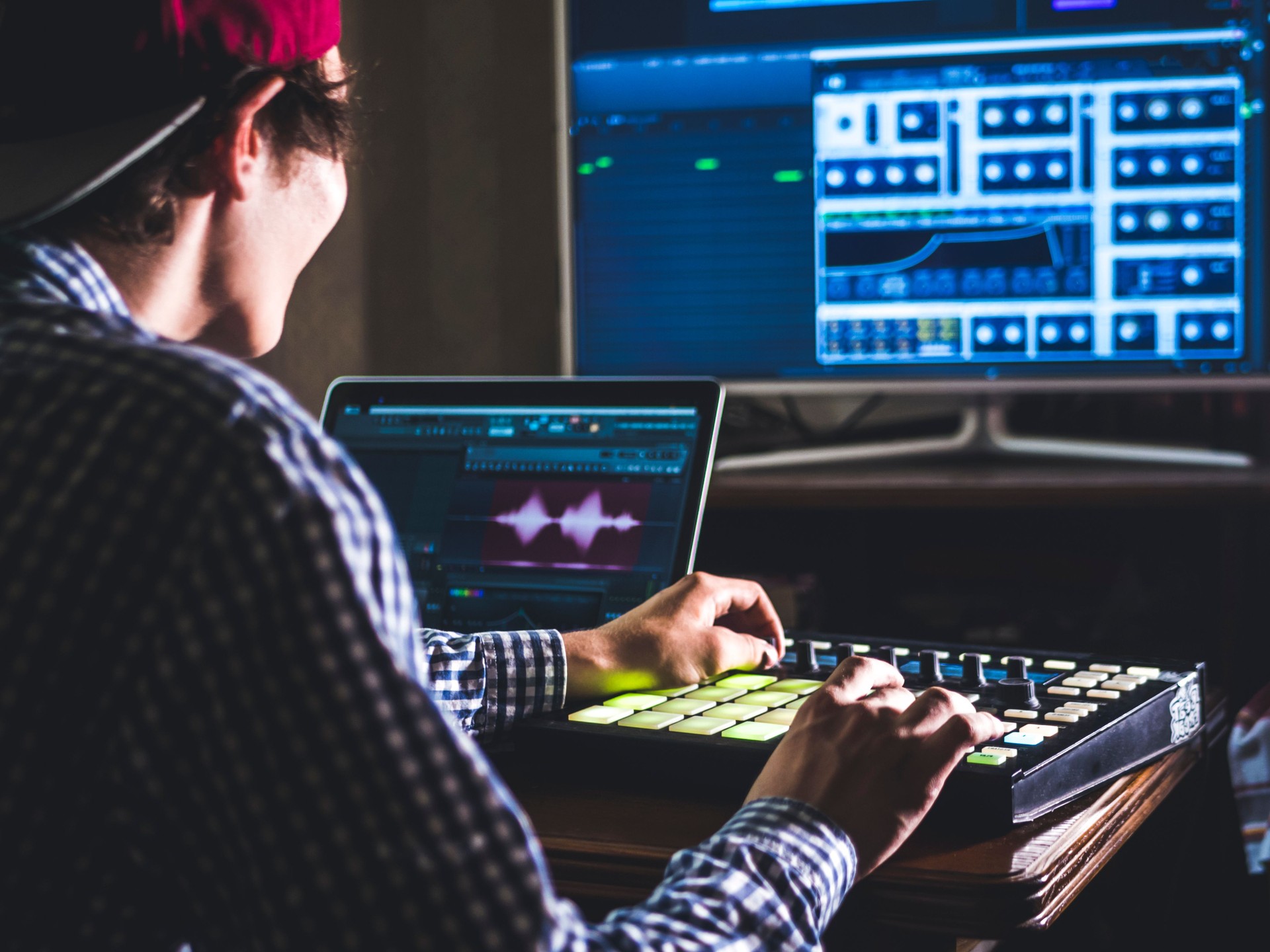 young male sound engineer working in professional music studio with modern equipment recording new track